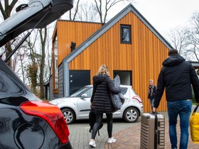 Gasten bij hun vakantiehuisje in een vakantiepark op de Veluwe