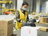 Een Chinese medewerker pakt artikelen in